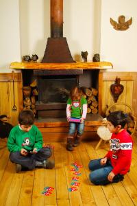 two children sitting on the floor in front of a fireplace at Casa Kalfu Hotel Boutique in Puerto Varas