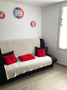 Bett mit roten Kissen auf einem Zimmer in der Unterkunft Tout schuss in Saint-Étienne-de-Tinée
