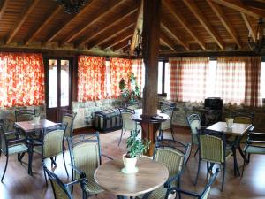 een eetkamer met tafels, stoelen en ramen bij Posada Ribera del Pas in Iruz