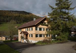 a large house with a mountain in the background at Försterhaus Mellau in Mellau