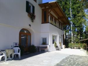 un edificio bianco con portico e balcone di Agri-park Casa Miramonte a Ronzone