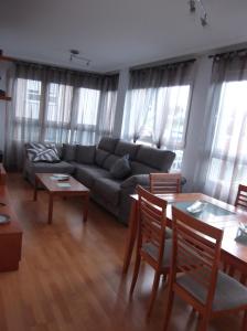 Solaina Parking gratuito في فيفييرو: غرفة معيشة مع أريكة وطاولات ونوافذ