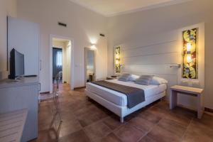 een slaapkamer met een bed en een flatscreen-tv bij Hotel Parco Degli Aromi Resort & SPA in Valderice