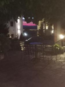 een tafel en stoelen in een tuin 's nachts bij Guesthouse Kolenti in Portariá