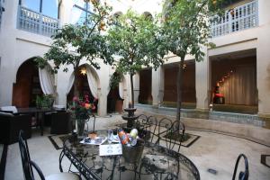 Una habitación con una mesa con un árbol. en Riad et Spa Misria Les Orangers en Marrakech
