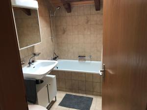 a bathroom with a bath tub and a sink at AmdenLodge - Gardens Chalet in Amden