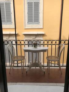 a white table and two chairs on a balcony at Rome dreaming house in Rome