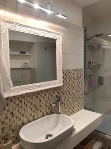 a bathroom with a sink and a shower with a mirror at Rome dreaming house in Rome