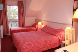 una camera d'albergo con letto e divano di Hotel Le Village a Gif-sur-Yvette