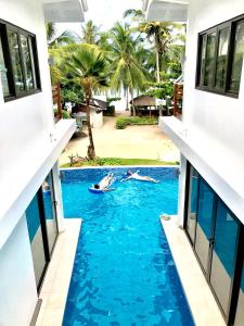 ein Paar schwimmt in einem Pool in der Mitte eines Gebäudes in der Unterkunft The Whitehouse by the Sea in Panglao