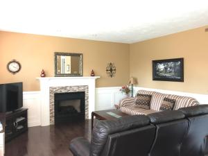 ein Wohnzimmer mit einem Sofa und einem Kamin in der Unterkunft Sweet home in Moncton