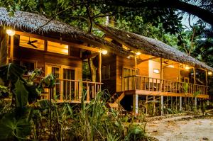 een houten huis met een rieten dak bij Amihan Bungalows in General Luna