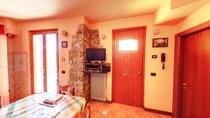 um quarto com uma cama, uma televisão e uma porta em Casa Magotina em Tavernola Bergamasca
