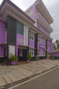 a purple building with potted plants in front of it at Raggea in Malang