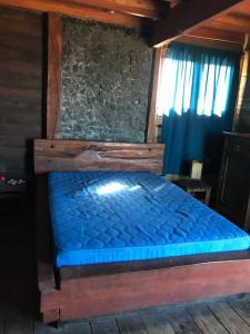 Cama en habitación con colchón azul en Casa del Diavolo, en Punta del Diablo