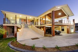 ein großes Haus mit einem Auto in der Einfahrt in der Unterkunft Ana Mandara Luxury Retreat in Port Macquarie