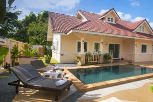a villa with a swimming pool in front of a house at Relax private Pool Villas - 4 bedroom villas in Ao Nang Beach