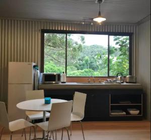 a kitchen with a table and a sink and a window at Avoca Beach and Bush in Avoca Beach