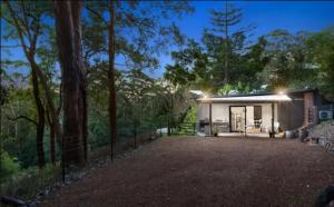 una casa con una gran entrada en el bosque en Avoca Beach and Bush, en Avoca Beach