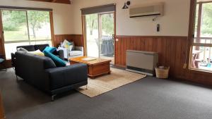 una sala de estar con un sofá y una mesa en Holiday Heights, en Halls Gap
