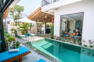 a villa with a swimming pool in a house at An Bang Beach Dolphin Homestay in Hoi An