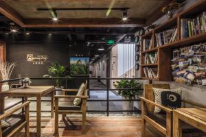 a room with a table and chairs and bookshelves at Chengdu Byway Trip Kuanzhai Alley Branch in Chengdu