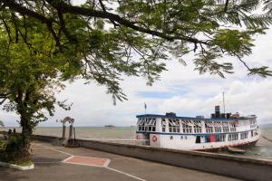 a boat is docked in the water next to a sidewalk at Quest Suva in Suva
