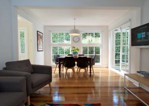 a living room with a table and chairs and a clock at Strahan House in Hobart