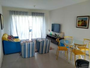 a living room with a table and chairs and a tv at Apto Villa das Aguas in Estância