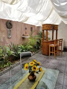 un vase rempli de tournesols assis sur une table dans l'établissement Casa Q BnB, à Mexico