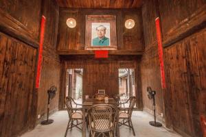 a dining room with a table with chairs and a picture on the wall at Laojia, a Qing dynasty house in Xingping