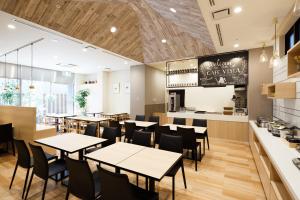 un restaurant avec des tables, des chaises et un comptoir dans l'établissement Hotel Vista Nagoya Nishiki, à Nagoya