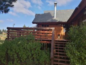 una cabaña de madera con una escalera que conduce a ella en lodge con piscina privada, parcela de campo. en Algarrobo