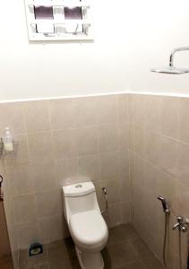 een badkamer met een toilet, een wastafel en een raam bij Twin Homestay A in Kuala Terengganu