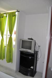 un televisor sentado en un stand en una habitación con ventana en Apartamento, en Santa Marta