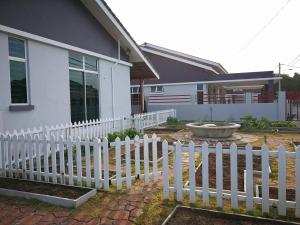 a white picket fence in front of a house at Greenery Garden Concept Homestay in Kuantan