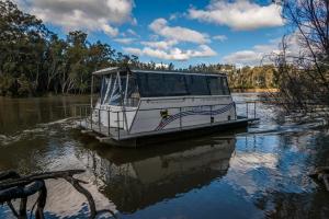 um barco flutuando sobre a água em um rio em Moama on Murray Houseboats em Moama