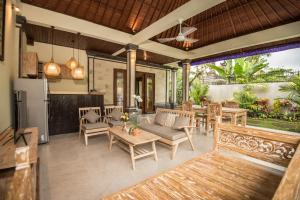 een woonkamer buiten met een tafel en stoelen bij Secret Bunutan Ubud Villa in Ubud