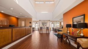 an office lobby with orange walls and a bar at Best Western Milton Inn in Milton
