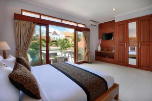 a bedroom with a large bed and a balcony at Villa Mawar Legian in Legian