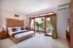 a bedroom with a bed and a sliding glass door at Villa Mawar Legian in Legian +18 photos