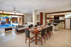 a dining room and living room with a table and chairs at Villa Mawar Legian in Legian