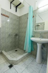 a bathroom with a shower and a sink and a shower at Costa-Rini Hotel in Leonidio