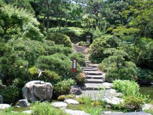 a garden with a stone path and a cross at Hotel Hagoromo in Shizuoka