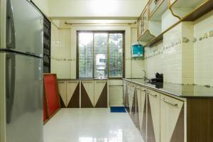 a large kitchen with a sink and a refrigerator at Comfortable Living in Navi Mumbai