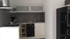 uma cozinha com armários brancos e um frigorífico preto em Eg em Wilhelmshaven