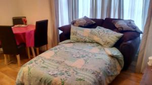 a bedroom with a couch and a bed with a blanket at Apartment Mary street in Porthcawl