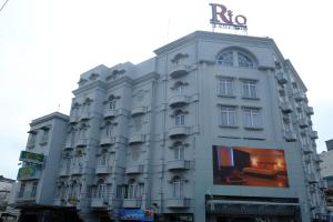 un gran edificio blanco con un cartel. en Rio City Hotel, en Palembang