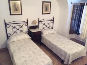 two beds sitting next to each other in a room at Casa Rural La Villa in Castro del Río