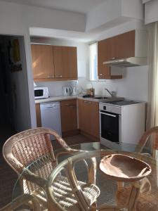 a kitchen with a glass table and two chairs in it at Villa L'Amiraute in Agde